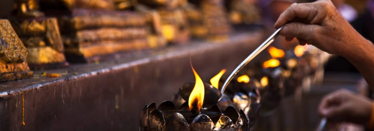CMLocals Chiang Mai Locals Thai Temple close up of lighting oil lamps in Buddhist temple